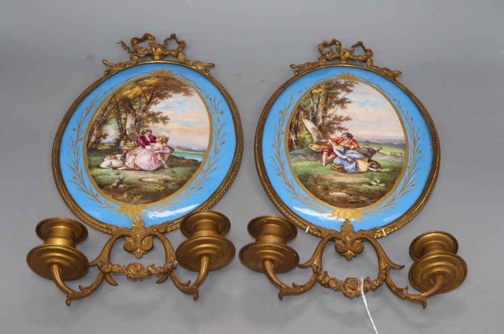 A pair of gilt brass two branch wall sconces with oval Sevres style plaques, length 40cm